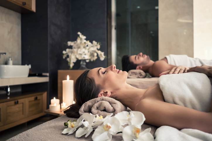 Man and woman lying down on massage beds at Asian wellness center Man and woman lying down on massage beds at Asian wellness center