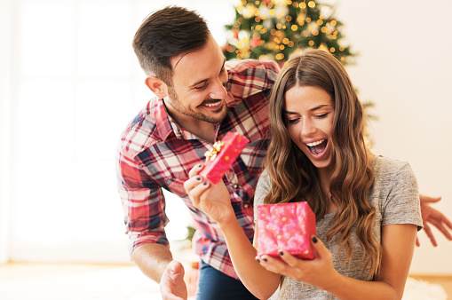 Man giving a Christmas present to his girlfriend Man giving a Christmas present to his girlfriend