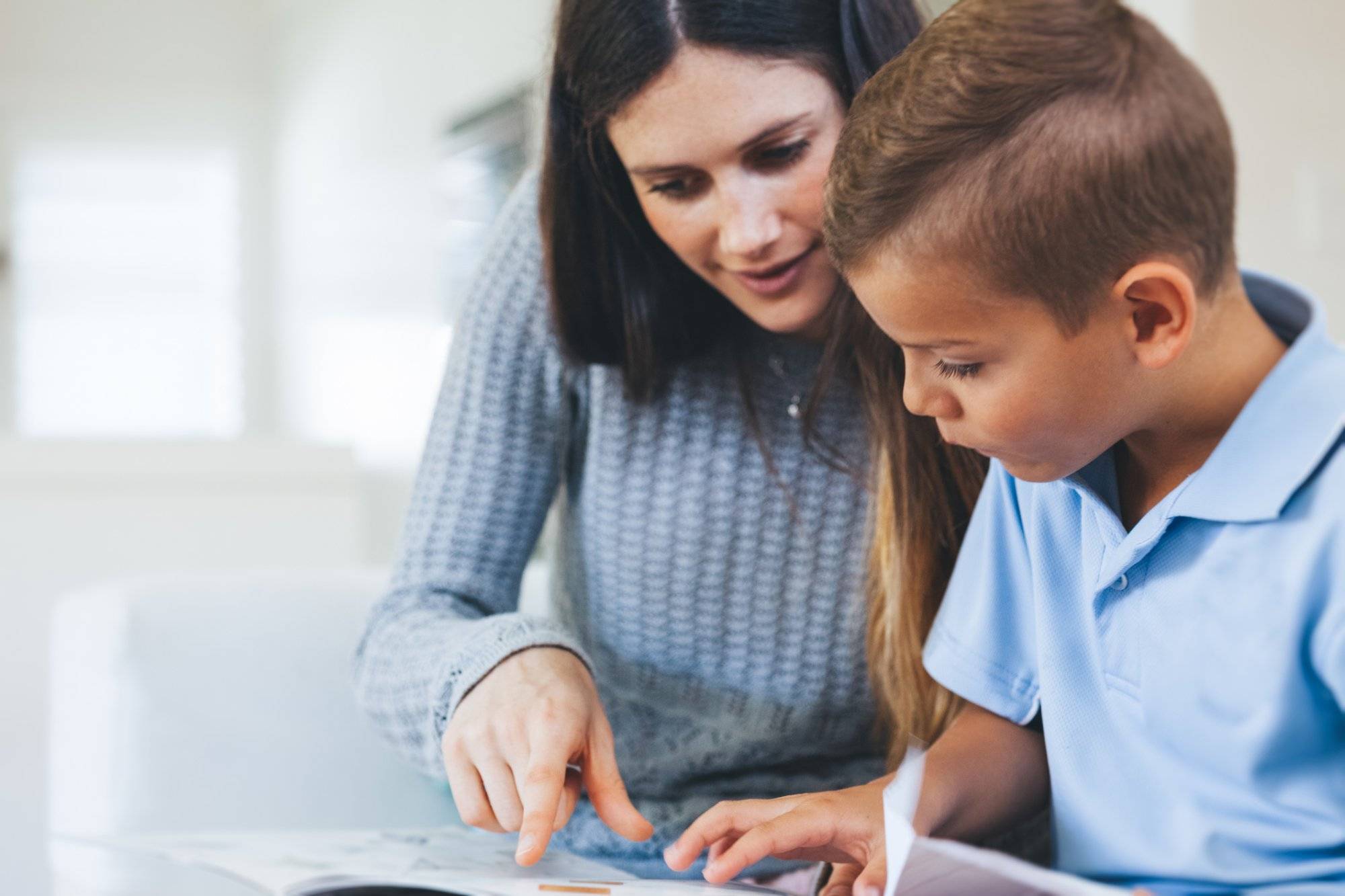 boy getting tutored with school assignment